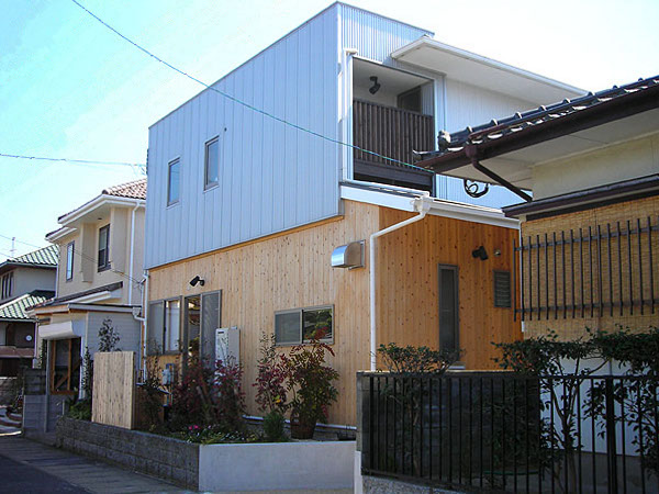 木造　福岡F邸1、道路側から見た外観で、1階の杉板と2階のガルバリウム鋼板がコントラストで目立ちます