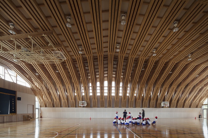 木造　三加和小中学校20、木材を重ねた梁の間に窓をつけて、やさしい明かりや通風を取っています